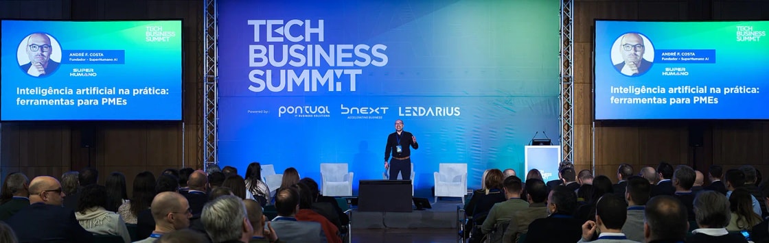 André Bacêlo e Costa em palco no Tech Business Summit 2025, perante uma plateia cheia, durante a palestra «Inteligência artificial na prática: ferramentas para PMEs»